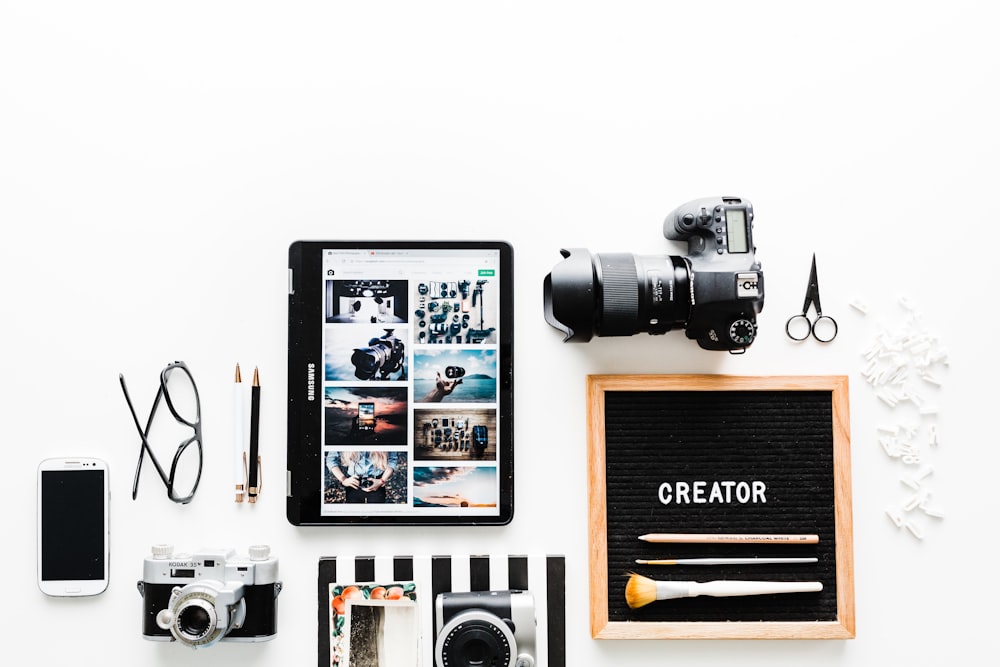 flat view of cameras beside computer tablet and smartphone