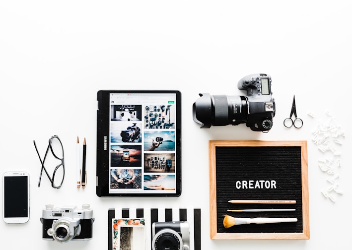 flat view of cameras beside computer tablet and smartphone