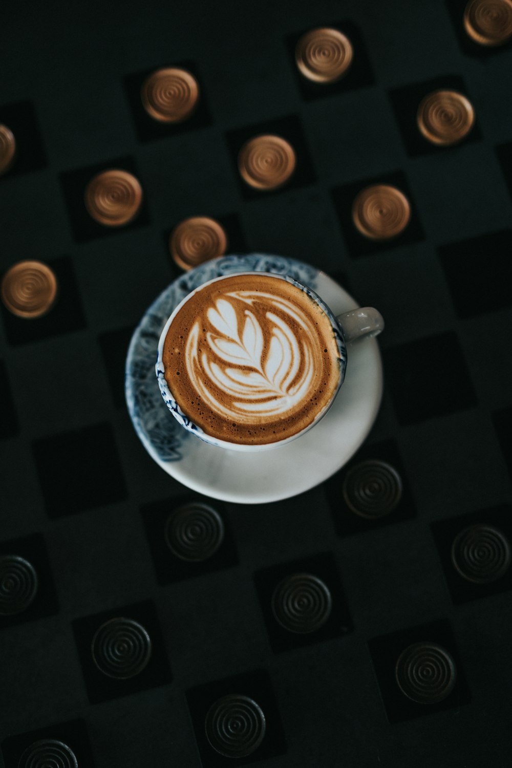 a cappuccino on a saucer on a black table