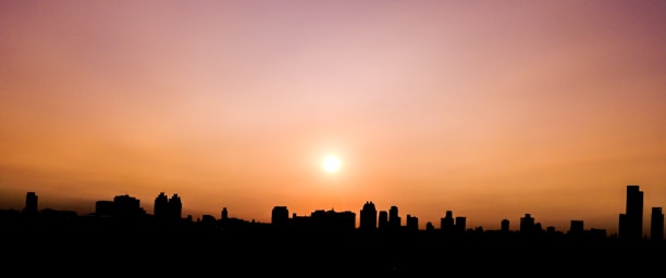 Photo of Philadelphia skyline at sunset with warm mustard tones.