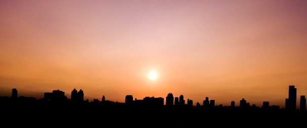 An artistic shot of a city skyline during sunset with warm hues.