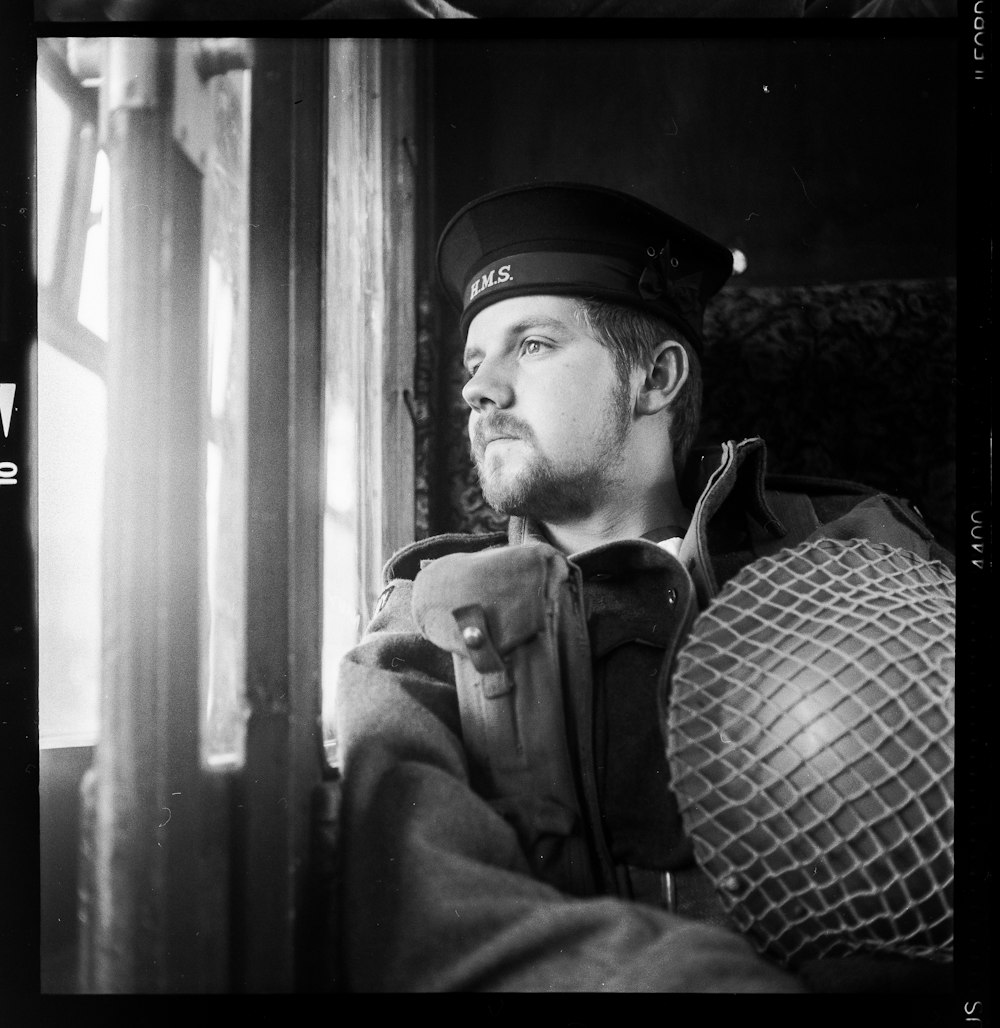 man sitting on bench holding vintage helmet