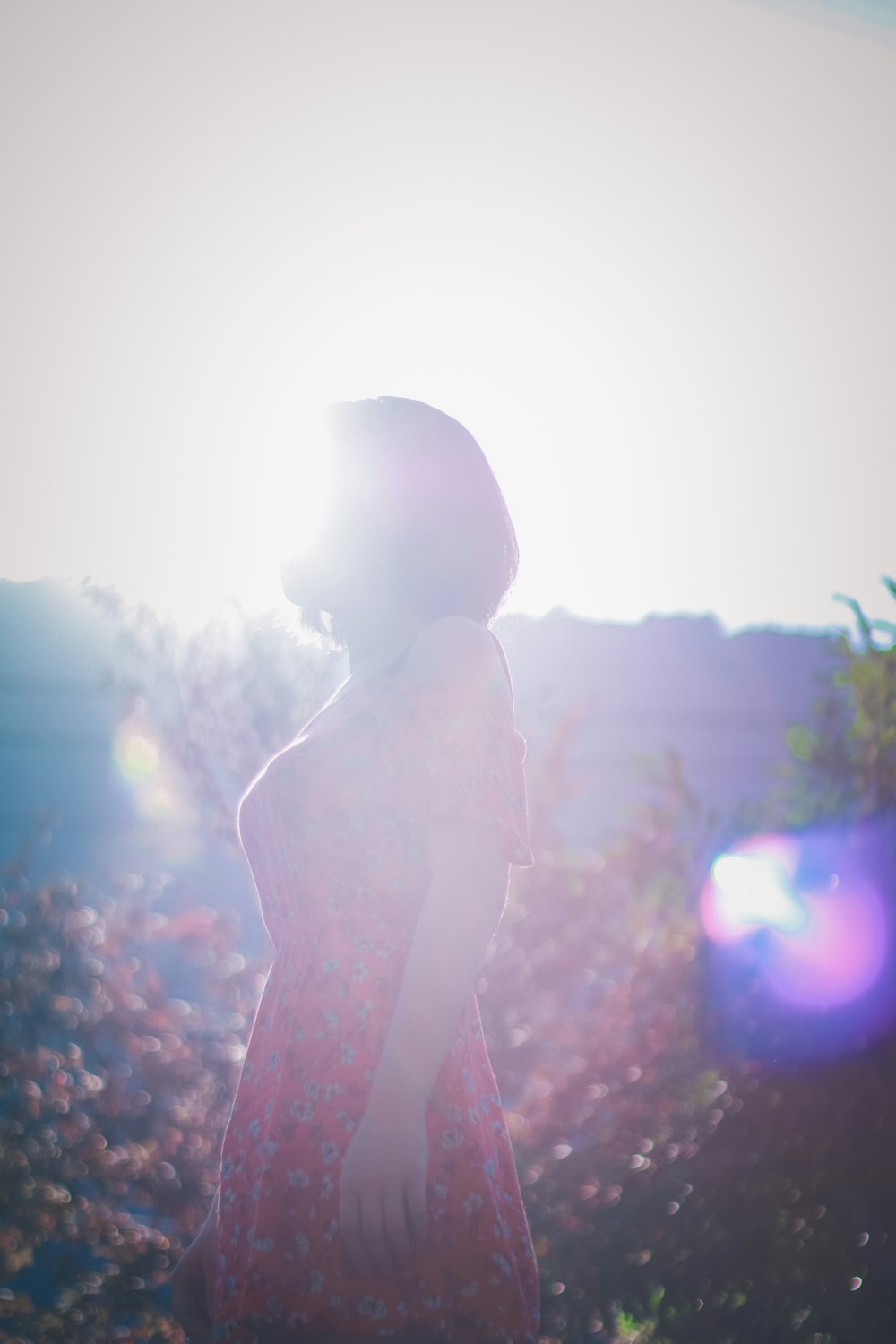 woman wearing red dress standing near flower at daytime