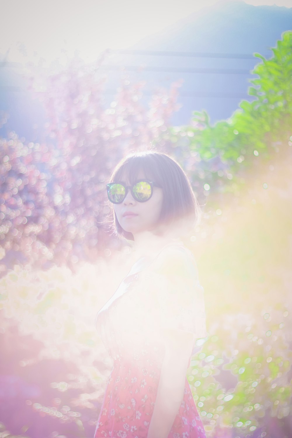 Frau mit Sonnenbrille, während sie in der Nähe von Bäumen steht