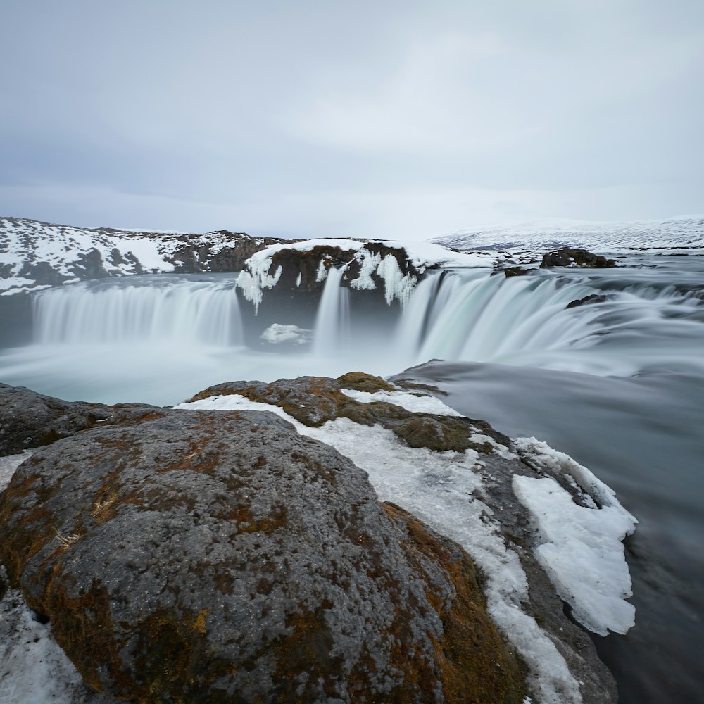 time lapse photo of waterfall beside rock formation