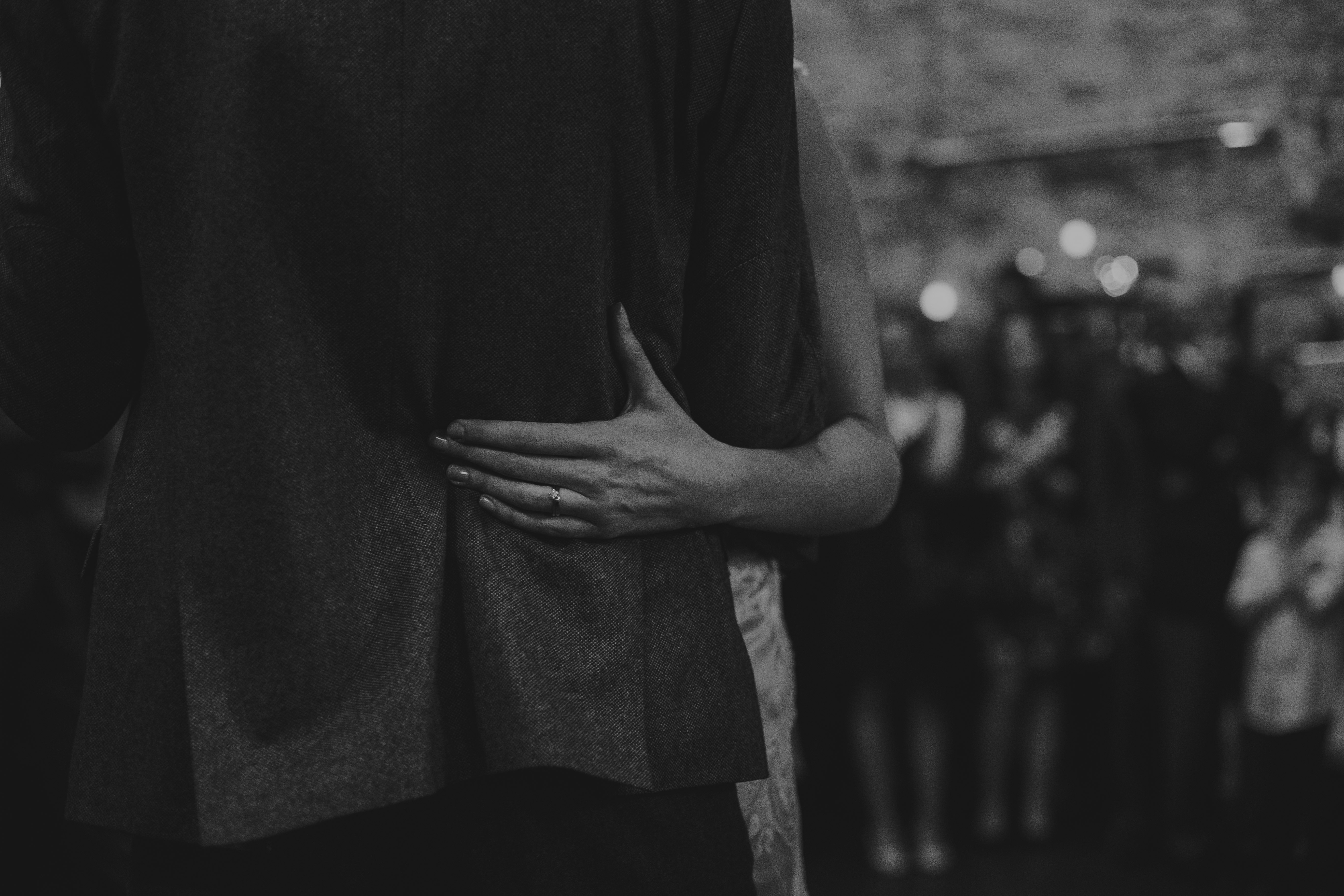 grayscale of person hugging another person