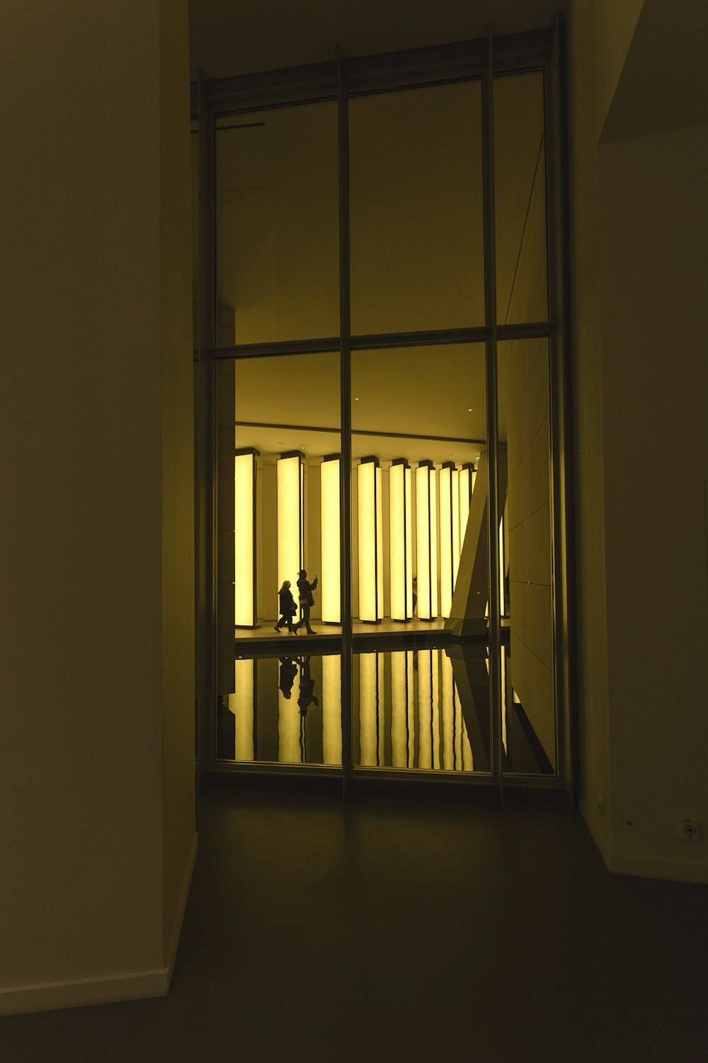 silhouette di due persone che camminano all'interno dell'edificio durante l'ora d'oro