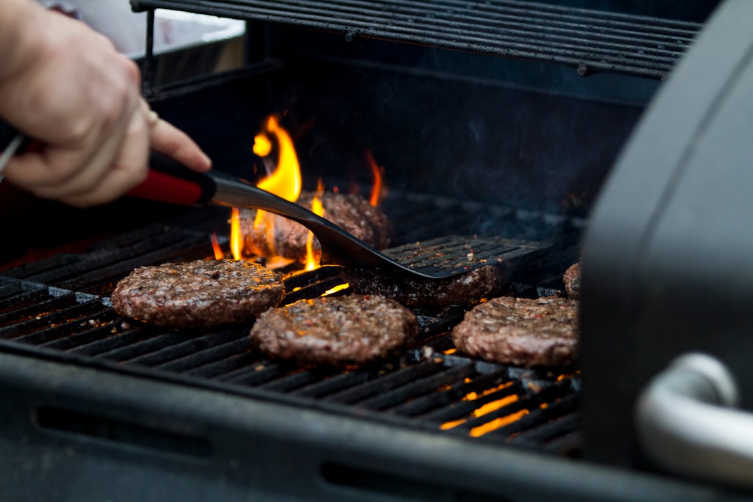 person grilling hamburger patties