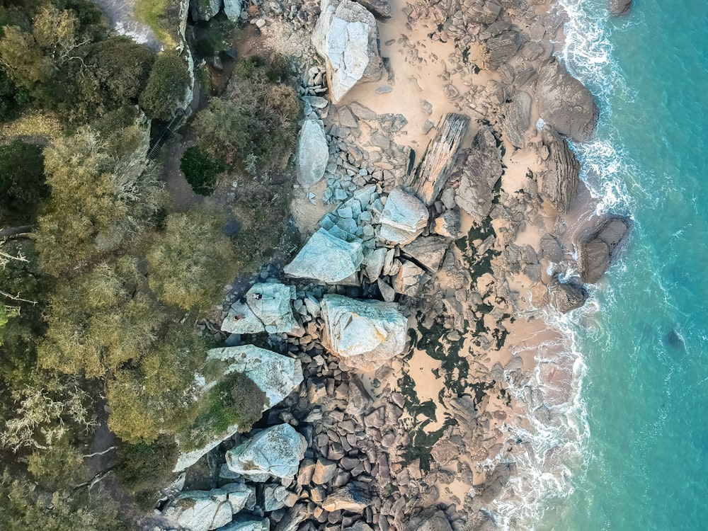 Photographie de vue aérienne de roches près d’un plan d’eau pendant la journée