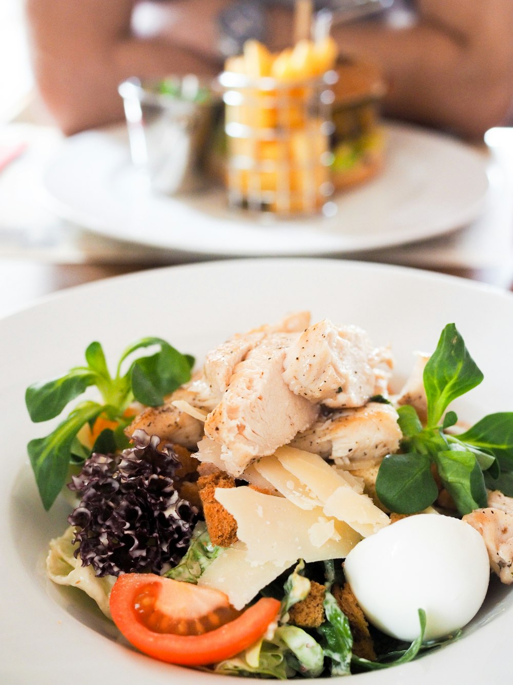 Ensalada de pollo servida en plato de cerámica blanca