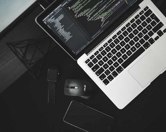 Developer working at a clean desk with multiple monitors showing code