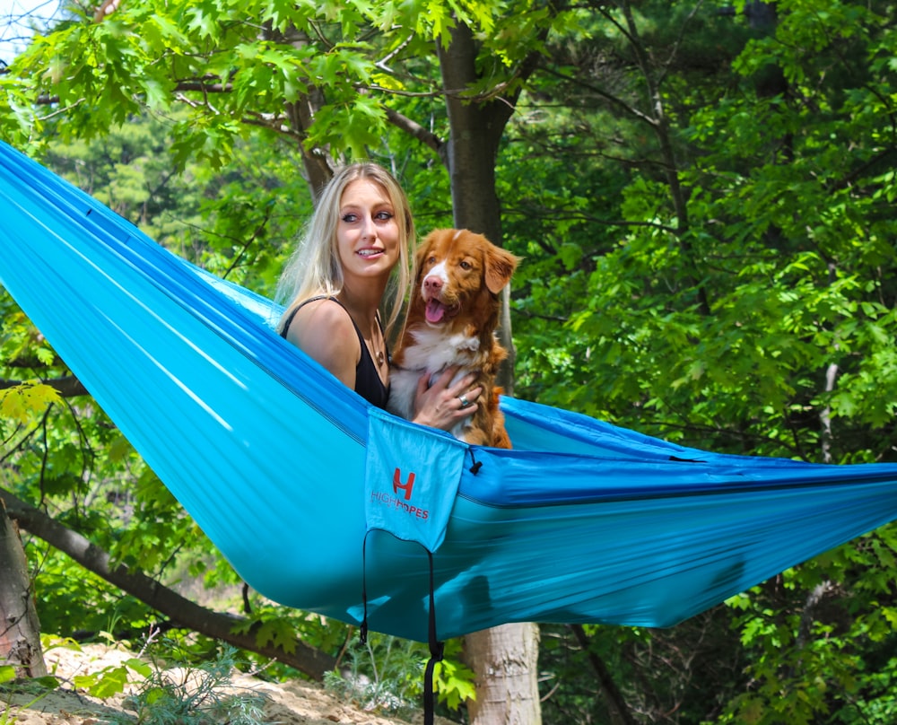 woman and dog on blue hammock
