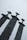 Three large swords stand upright, embedded in the ground with their blades pointing towards the sky. The swords have distinct, oversized hilts and are made of a weathered, dark metal. The background is a pale, overcast sky, adding a cool, subdued atmosphere to the scene.