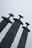 Three large swords stand upright, embedded in the ground with their blades pointing towards the sky. The swords have distinct, oversized hilts and are made of a weathered, dark metal. The background is a pale, overcast sky, adding a cool, subdued atmosphere to the scene.