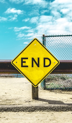 End sign on beige sand