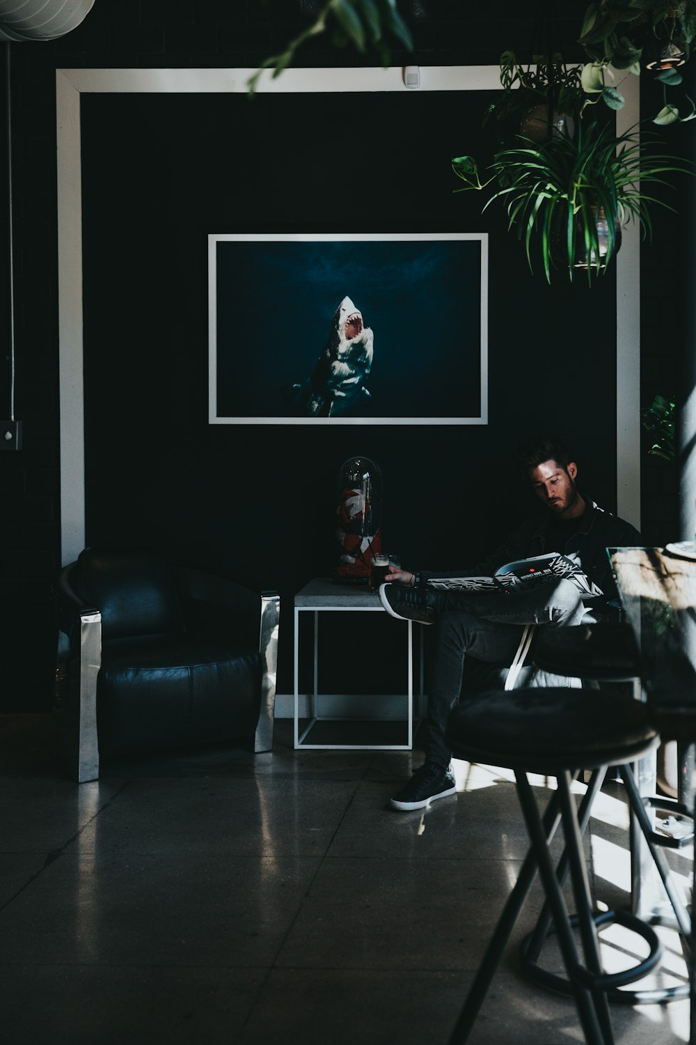 man sitting on chair reading magazine