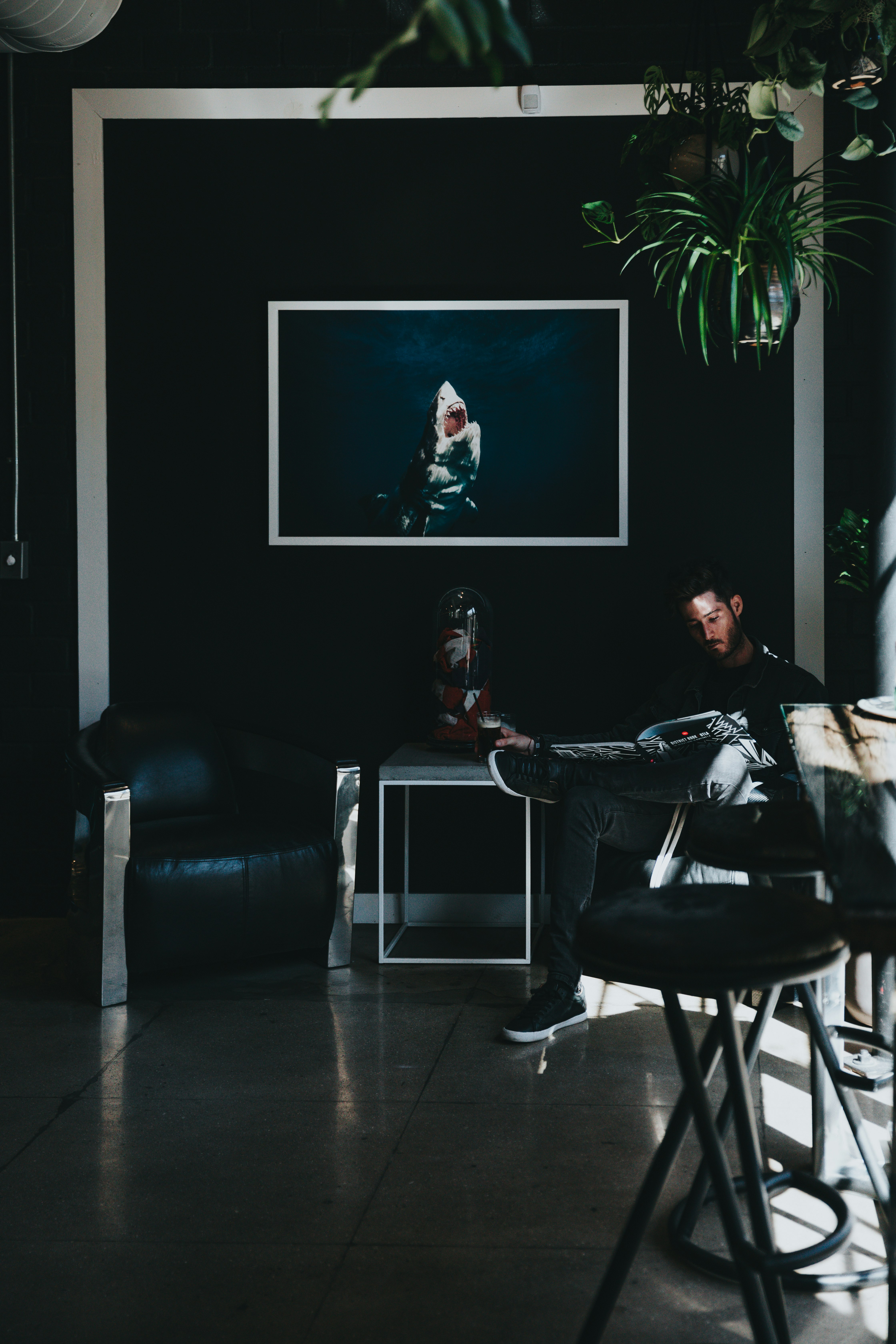 man sitting on chair reading magazine