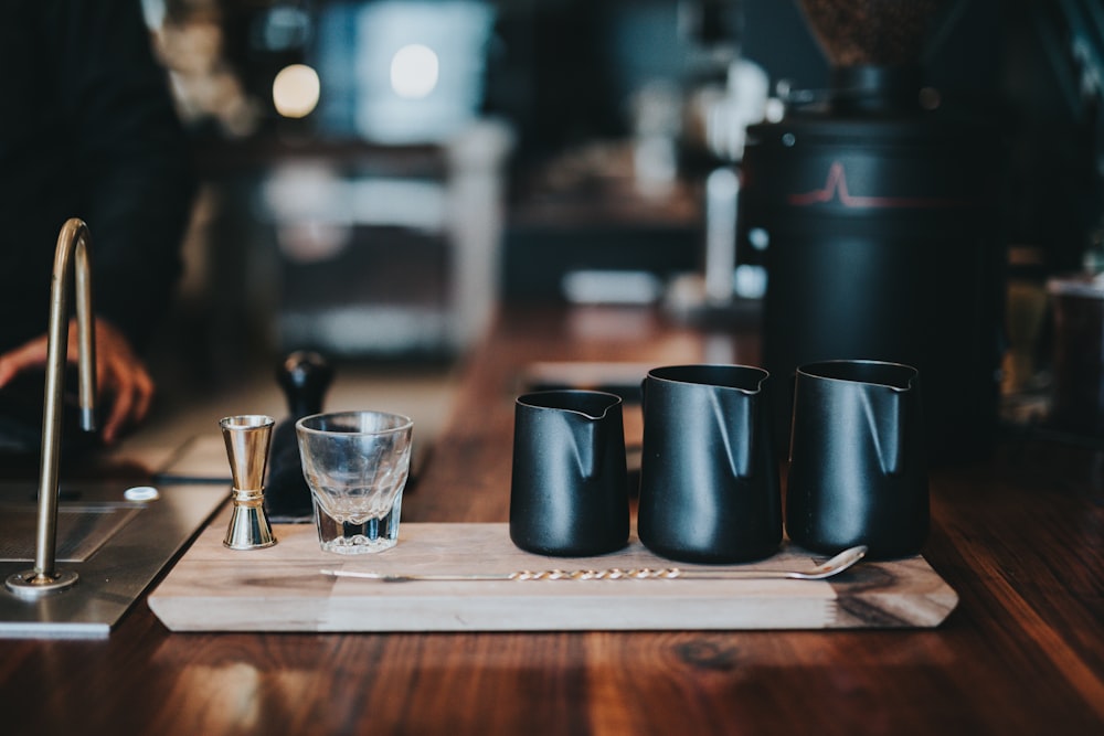 three black milk jars on brown table