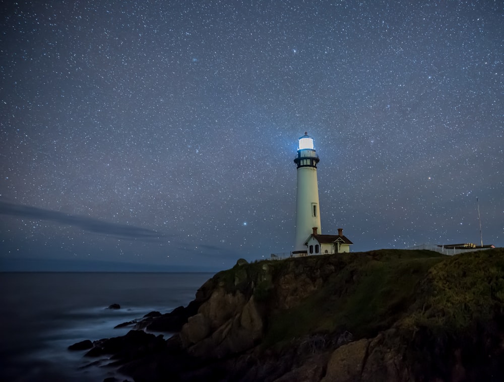 white light house near body of water