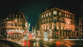 street photography of roads between buildings at night