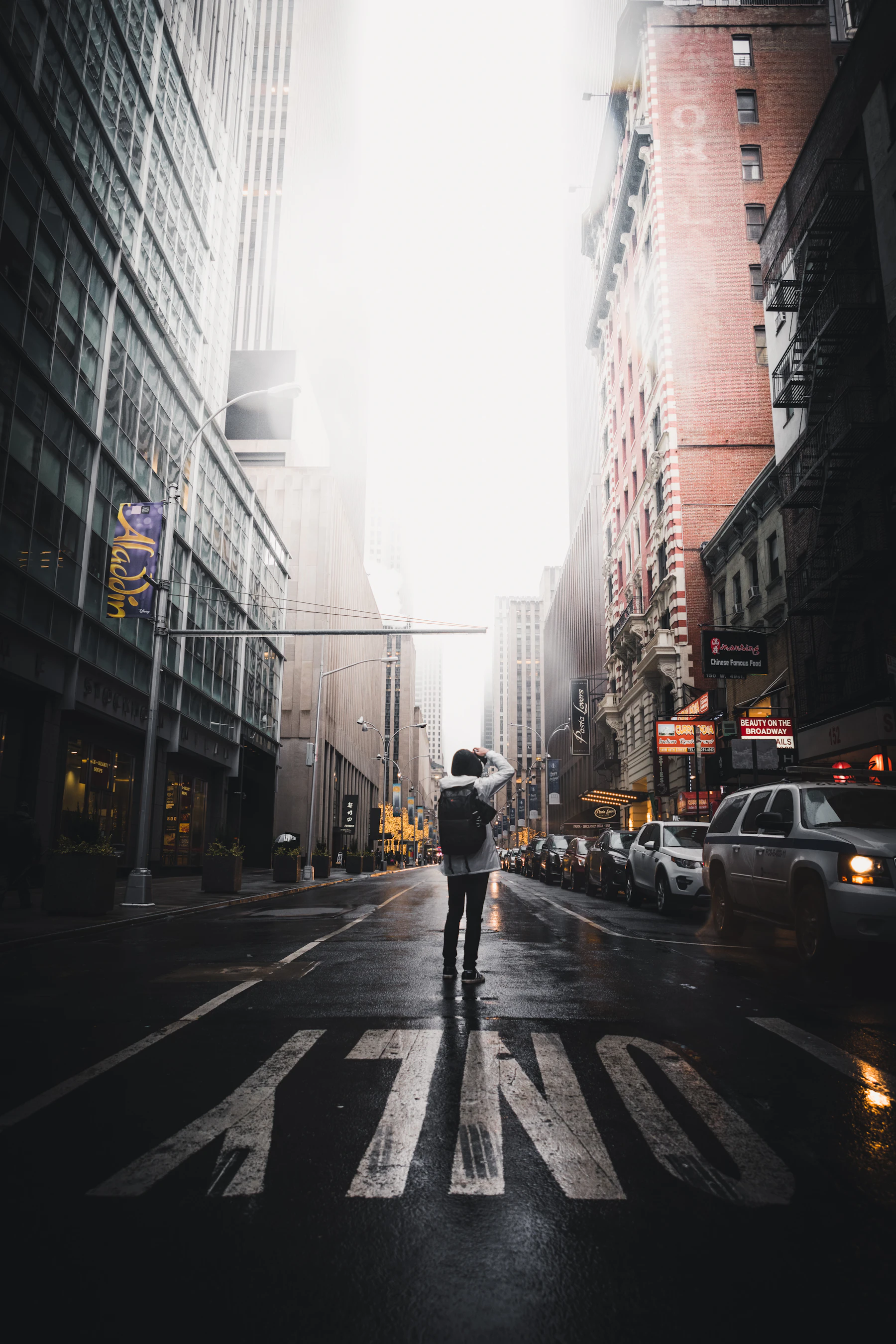 A lone figure standing in an empty city street washed in golden-hour light