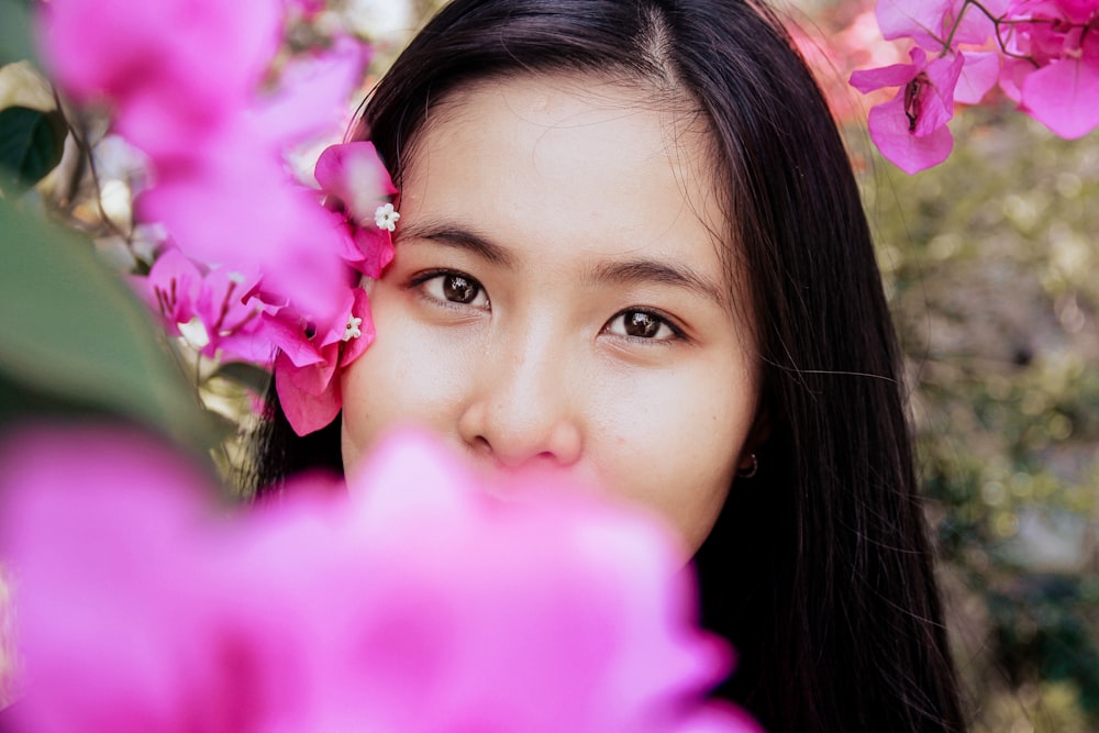 ピンクの花に覆われた女性の浅い焦点写真