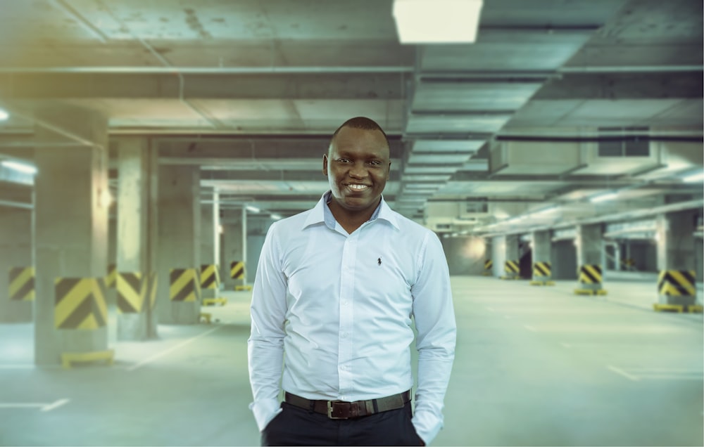 man wearing white dress shirt standing inside parking lot