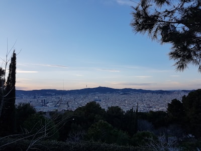 A panoramic view of Xanxerê cityscape with green hills and colorful buildings under a clear blue sky.