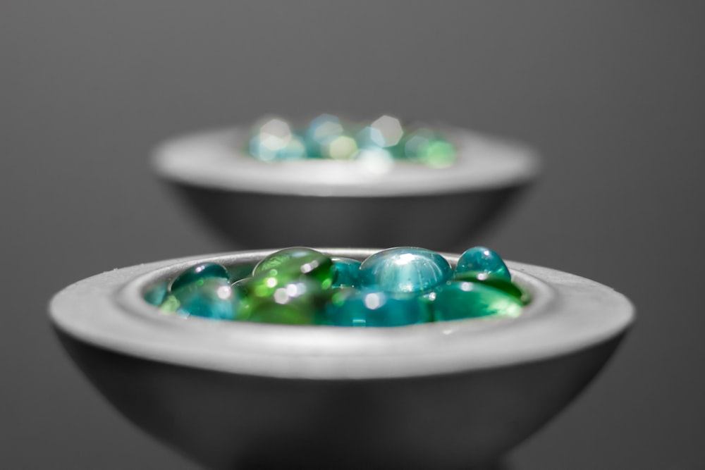 green round fruits on white ceramic bowl