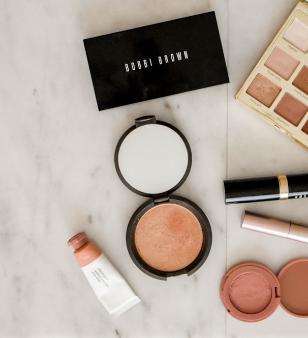 photo of assorted makeup products on gray surface