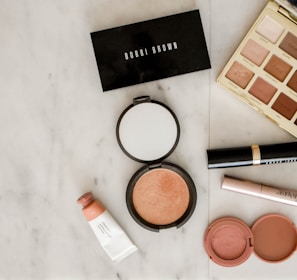 photo of assorted makeup products on gray surface