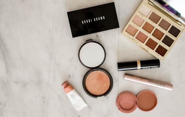 photo of assorted makeup products on gray surface