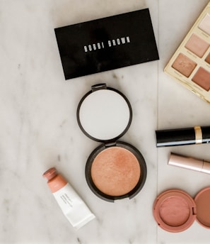 photo of assorted makeup products on gray surface