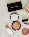 photo of assorted makeup products on gray surface