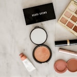 photo of assorted makeup products on gray surface