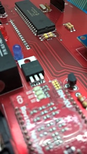 A close-up photo of hands assembling an old circuit board with glowing violet and cyan light accents.