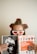 A person with hair rollers and wearing white cat-eye sunglasses is looking over a Fortune magazine. The magazine features a cover with an orange section titled 'The 100 Best Companies to Work For 2016'. The person holds the magazine while appearing to be in a relaxed setting.