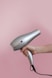 person holding gray corded hair dryer