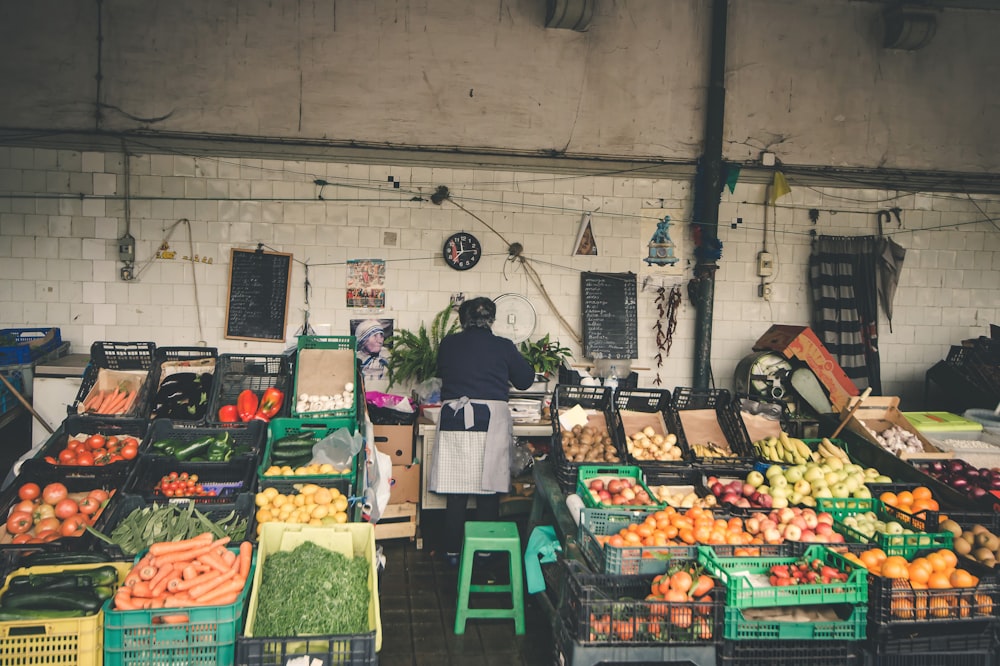 Persona in piedi al bancarello di frutta e verdura
