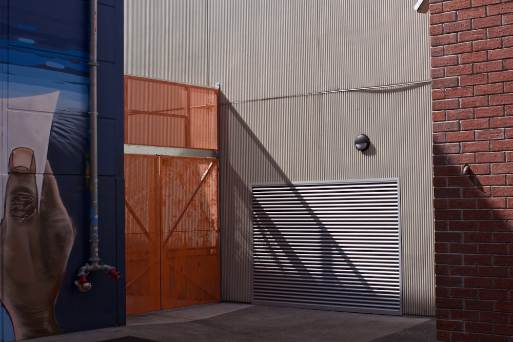 white roller shutter beside orange metal gate