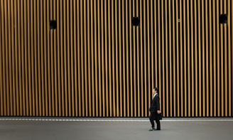 man in black suit jacket walking on road