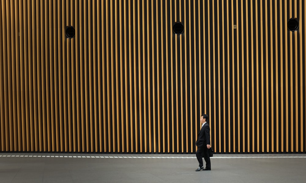 man in black suit jacket walking on road