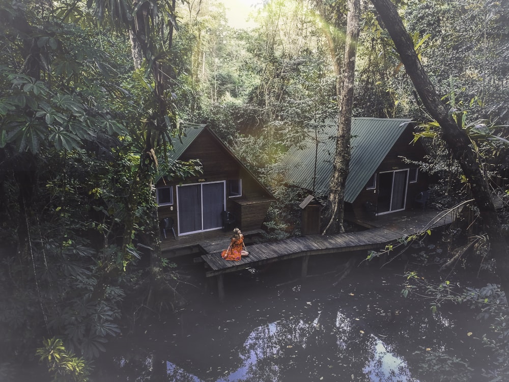 person sitting on wooden dock