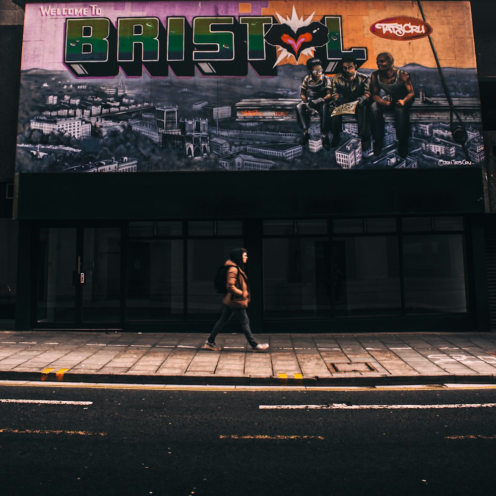 person walking on street beside store