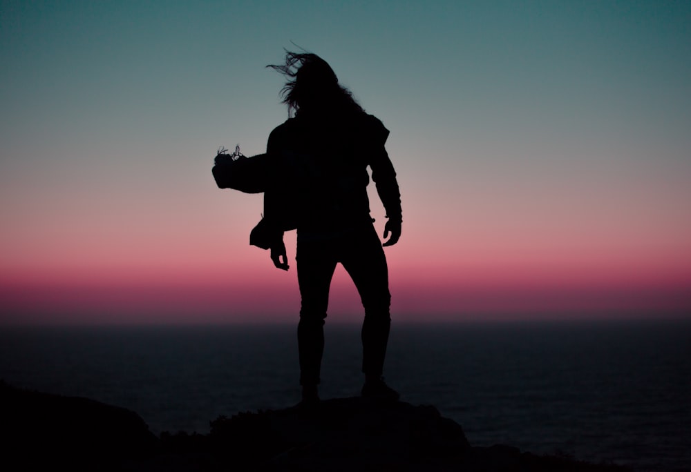 silhoutte of person standing on mountain