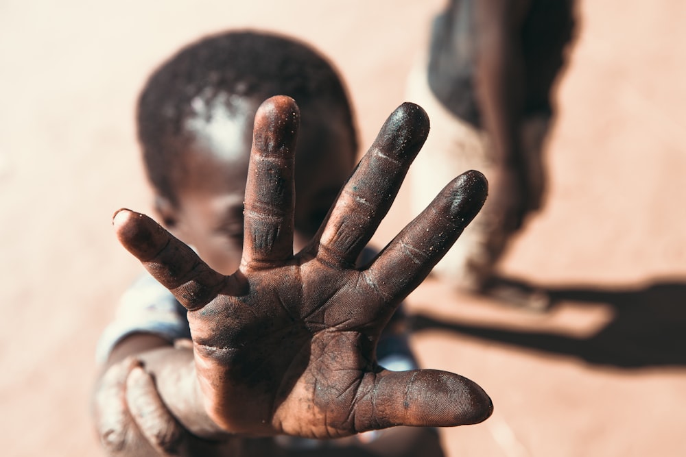 boy with black stain on hand