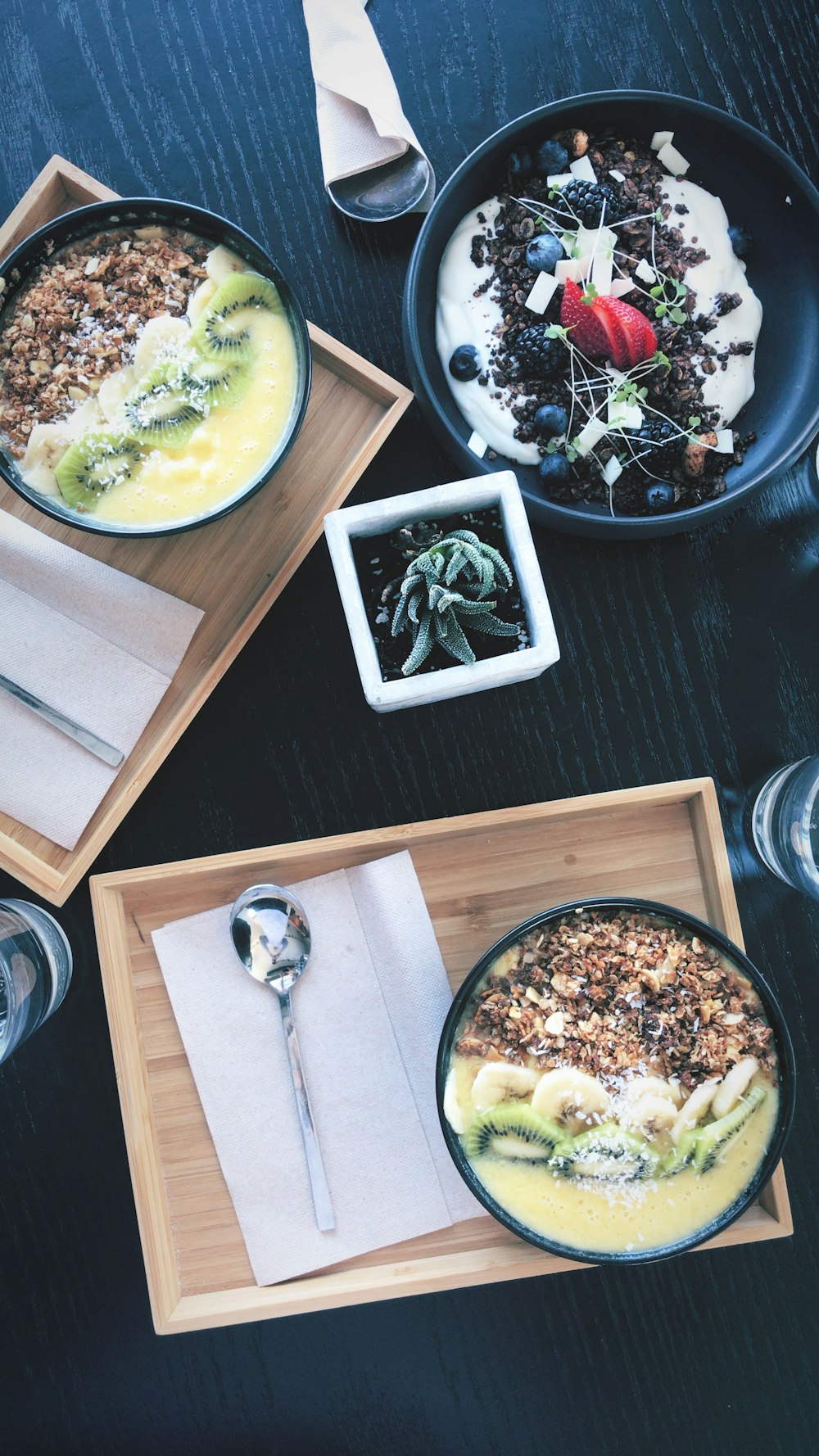 Müslischüssel mit Kiwi und Banane auf braunem Holztablett