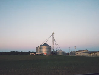 Aerial view of a farm landscape with big bags scattered near grain silos, highlighting logistics.