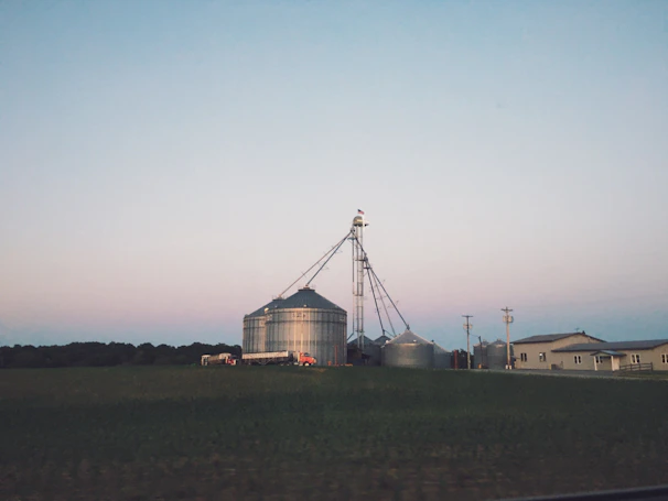 Aerial view of a farm landscape with big bags scattered near grain silos, highlighting logistics.