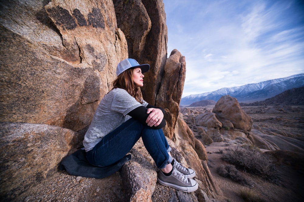 woman sitting on brown rock formation
